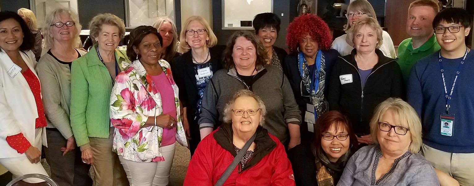 A smiling group of Ombudsman in semi-formal wear.